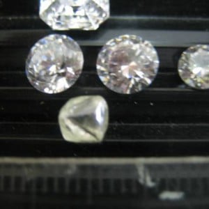 1.31ct distorted Octahedra beside 6.5mm CZ's