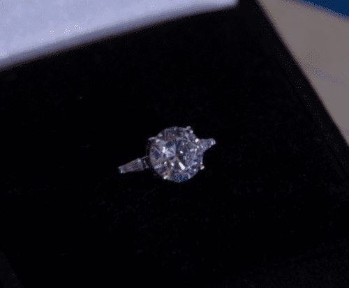 a diamond engagement ring in a black ring box