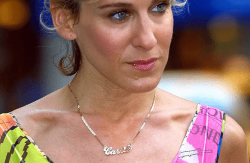 Carrie Bradshaw in her Carrie signature gold necklace